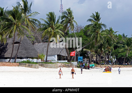 Tropical spiaggia di sabbia bianca e paglia in stile africano edifici Diani Beach Kenya Foto Stock
