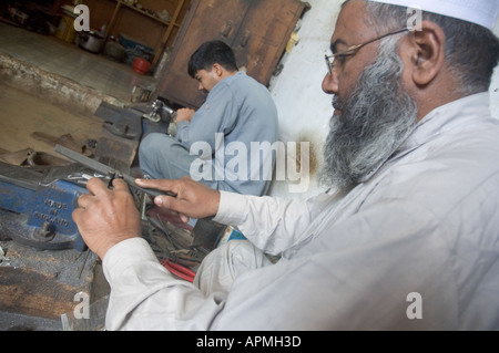 Due gunmakers al lavoro a Darra Adam Khel Pakistan bracci più grande bazaar Foto Stock