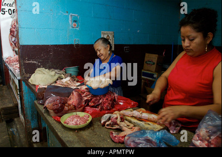 Le donne del rivestimento di organi animali a vendere a un macellaio stand nel mercato centrale di Antigua Guatemala nel marzo 2005 Foto Stock