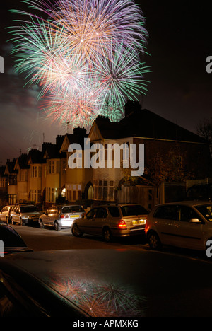 Fuochi d'artificio esplosione di colori sulla fila di case a Londra di Notte Foto Stock