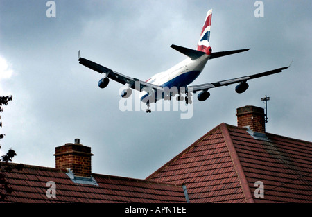 Bassa battenti British Airways jet sfiora i tetti che si avvicina all'aeroporto Heathrow di Londra. Foto Stock