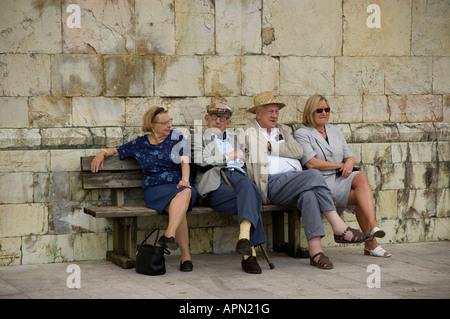 I turisti prendere un periodo di riposo al di fuori del Duomo (Cattedrale) nella parte superiore di Barga in Toscana Foto Stock