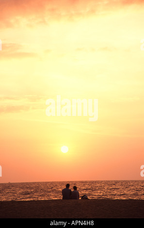 Lo SRI LANKA. Una giovane coppia godendo del tramonto dalla spiaggia di Negombo. Foto Stock