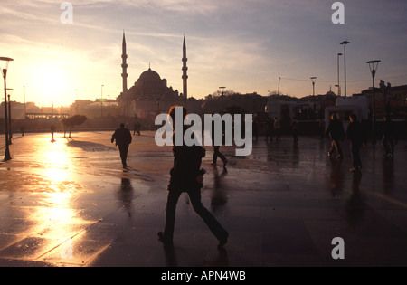 ISTANBUL, Turchia. Un autunno / inverno sunrise nel quartiere Eminonu, con recentemente arrivati i passeggeri del traghetto sul loro modo di lavorare. 2006. Foto Stock