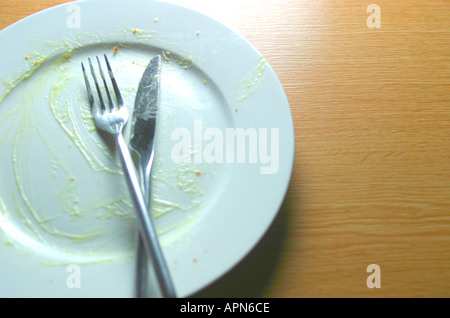 Vuoto utilizzato la cena piastra con coltello e forchetta sul piano portapaziente Foto Stock