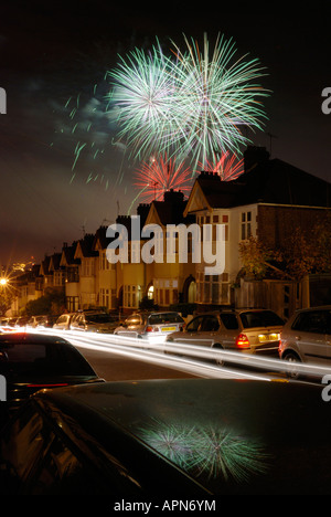 Fuochi d'artificio esplosione di colori sulla fila di case a Londra di Notte Foto Stock
