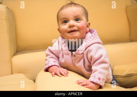 Un bambino gioca amongs divano cuscini a casa Foto Stock