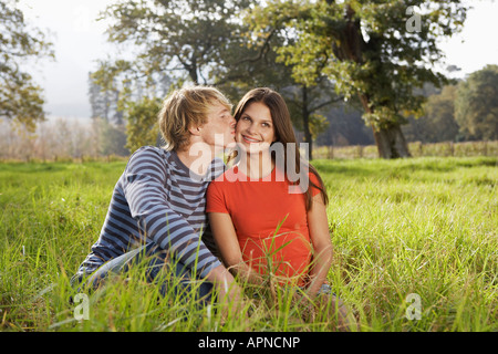 Teenage giovane seduto nel campo Foto Stock