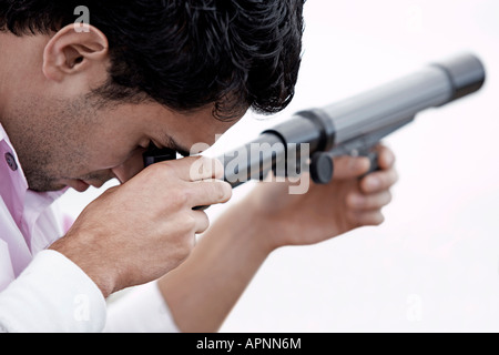 Giovane uomo utilizzando un telescopio Foto Stock