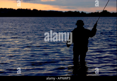 Pescatore di Pesca a Mosca Report di Pesca sul serbatoio Stoneyford al tramonto nella contea di Antrim Irlanda del Nord Foto Stock