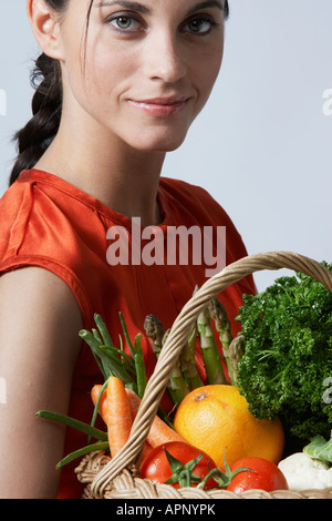 Giovane Donna con cesto di vegetali Foto Stock