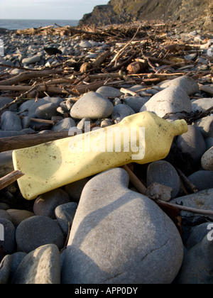 Giallo sfumato la bottiglia di plastica lavati fino sulla spiaggia di ciottoli Aberystwyth Wales UK Foto Stock