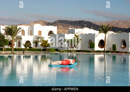 Babbo Natale sorseggiando un cocktail su un lilo in una piscina Foto Stock