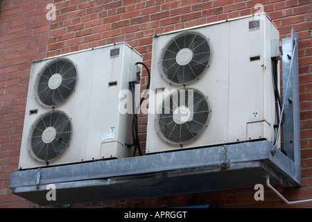 Due hitachi sovralimentare le unità aria condizionata fissato al di fuori di un rosso mattone office parete edilizia Belfast Foto Stock