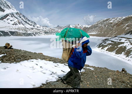Porter arrivando a Tilicho Lake. Lago più alto al mondo (4919m). Circuito di Annapurna trek. Il Nepal Foto Stock