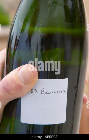 Herve Jestin, enologo e enologo tenendo una bottiglia di champagne Beuverie 1983 annata che egli si irrorano manualmente Foto Stock