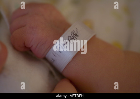 Close up femminile di neonato mano a 4 giorni vecchio ospedale braccialetto di riconoscimento Foto Stock