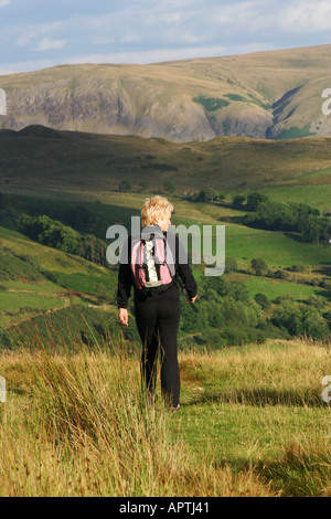 Donna che cammina sul grande Mell cadde, Lake District, REGNO UNITO Foto Stock