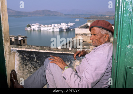 Un guardiano del Palazzo della Città in alto sopra il Lago di Pichola e il suo Palazzo del Lago (Jag Niwas), Udaipur IN Foto Stock