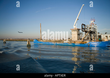 Draga al lavoro nella laguna veneziana sulla rotta dall'aeroporto Marco Polo per la città di Venezia, Italia Foto Stock