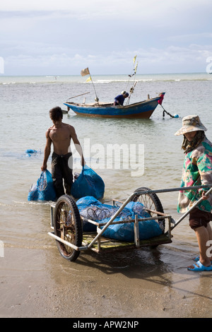 I pescatori (granchi) spostano le reti di granchio verso la terra tramite carrello a mano sulla spiaggia di Phala vicino a Rayong Thailandia. Foto Stock