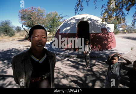 Maestro Toma N avi di fronte Den ui villaggio con i suoi allievi Bushmanland Namibia Foto Stock