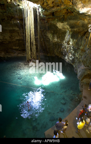 I visitatori osservano nuotatore in Xkeken Dzitnup Cenote vicino a Valladolid Yucatan Messico Foto Stock