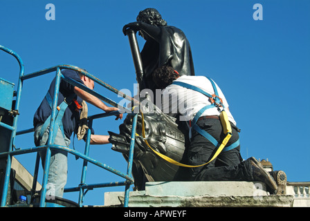 Londra due operai di eseguire i lavori di manutenzione di livello elevato scultura con l aiuto di un cherry picker paranco Foto Stock