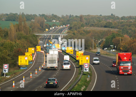 Traffico sulla A12 strada statale Ingatestone bypass velocità telecamera segnale di avvertimento e cambio corsia cartelli gialli coni indicazioni vicino a lavori stradali Essex Inghilterra UK Foto Stock