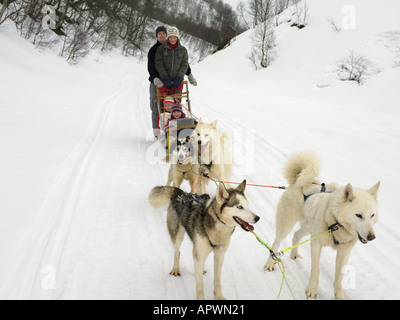 Famiglia su una slitta trainata da cani Foto Stock