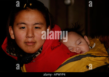 Inupiat giovane ragazza con un neonato gemelli nel villaggio di artico di baratto Kaktovik Isola Foto Stock