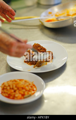 La preparazione di stufato di coniglio in ristorante toscano, Italia Foto Stock