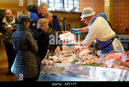 Pesce umido Shop Shopping cliente Cardiff Galles pescivendolo nella città mercato coperto Foto Stock