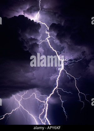 Di fulmini colpiscono drasticamente da una notte buia e tempestosa del cielo. Le nuvole glow viola e sono inquietanti contro la notte oscura. Foto Stock