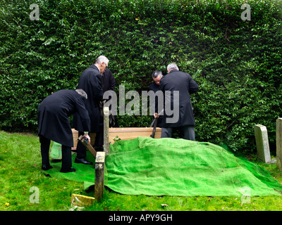 Funerale Saint Martins Chiesa East Horsley Surrey in Inghilterra abbassando bara nella tomba Foto Stock