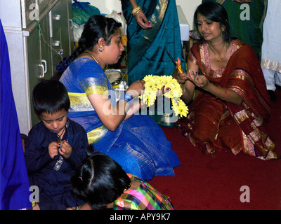 Murugan Temple New Malden Surrey in Inghilterra le donne fare ghirlande per gli dèi Foto Stock