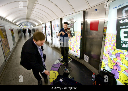 Un suonatore ambulante suona il violino in un tunnel per collegare il tubo le stazioni della metropolitana di Londra il 5 dicembre 2007 Foto Stock