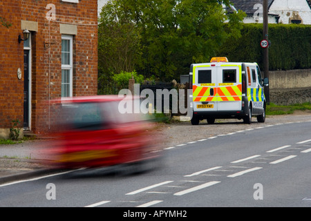 Red berlina velocizzando il passato 30 mph polizia mobile speed trap per la sicurezza del traffico JMH1769 Foto Stock