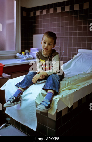 Ragazzo in attesa di gesso braccio rotto Foto Stock