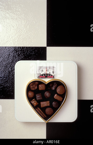 A forma di cuore Scatola caramella sulla bilancia da bagno Foto Stock