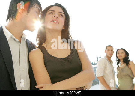 Uomo che parla di una donna di orecchio Foto Stock