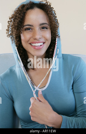 Giovane donna sorridente in telecamera Foto Stock