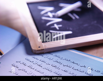 Scuola prenota con ardesia sulla quale i numeri sono scritti in lingua araba Foto Stock