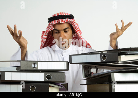 Giovane arabo uomo seduto con un sacco di file Foto Stock