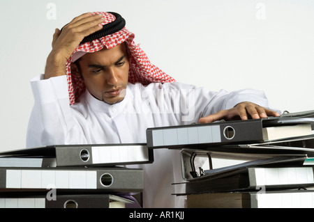 Giovane arabo uomo seduto con un sacco di file Foto Stock