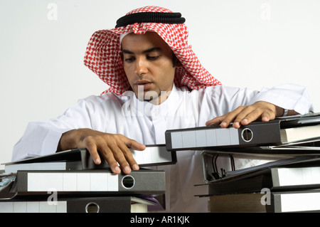 Giovane arabo uomo seduto con un sacco di file Foto Stock