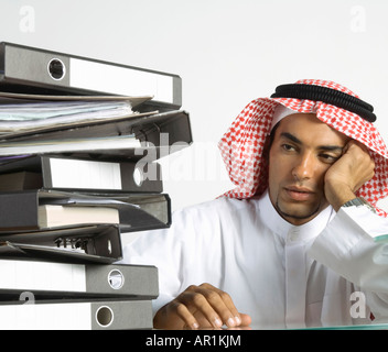 Giovane arabo uomo seduto con un sacco di file Foto Stock