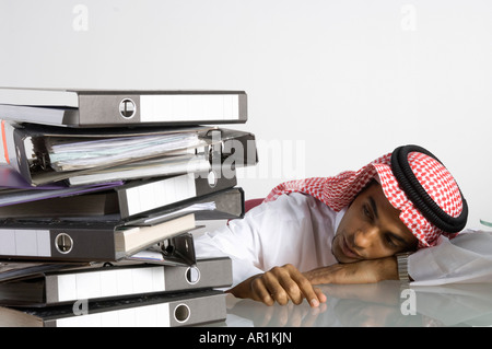 Giovane arabo uomo seduto con un sacco di file Foto Stock