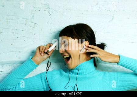 Piscina studio close up donna 25 30 brunette ciuffo ritratto golf jersey maglione emozioni blu sorridente sorriso di gioia cantare singi Foto Stock