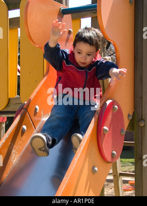 Tre anni di vecchio ragazzo sul parco giochi slitta Foto Stock